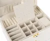 An open white jewelry box with multiple compartments for organizing jewelry. Podgląd zdjęcia produktu