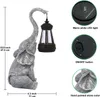 A solar-powered elephant statue holding a lantern, with close-ups of its features and dimensions. Produktbild-Vorschau
