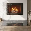 A glass hearth mat with a marble pattern is placed in front of a fireplace with a fire burning. Náhled obrázku produktu
