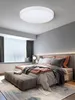 A modern bedroom with a bed, bench, and a ceiling light. Náhled obrázku produktu