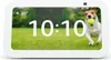 A white smart display showing the time and a dog playing with a ball in a grassy field. Produktbild-Vorschau