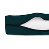 A close-up view of a dark green cushion cover with a zipper partially open, revealing the white filling inside. The background is plain white. Produktbild-Vorschau