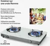 A gas cooktop with two burners, shown with a group of people enjoying a meal in the background. Podgląd zdjęcia produktu