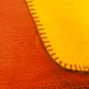 A close-up view of two pieces of fabric stitched together, one orange and one yellow. Produktbild-Vorschau