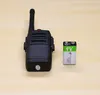 A black walkie-talkie and a 9V battery are placed on a wooden surface. Produktbild-Vorschau