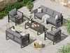 An outdoor furniture set arranged on a patio with plants and stone wall in the background. Produktbild-Vorschau