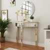 A mirrored console table with decorative items and plants in a room. Produktbild-Vorschau