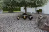 Three decorative globe lights are placed on a gravel path under a tree, with a white building in the background. Produktbild-Vorschau
