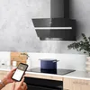 A modern kitchen counter with a range hood, induction hob, and a person using a smartphone. Náhled obrázku produktu