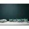 Several boxes of cleaning product are arranged on a white surface in front of a dark teal background. A stack of folded towels is to the left of the boxes. Produktbild-Vorschau