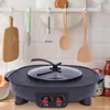 A black electric grill and hot pot with a glass lid sits on a wooden countertop, with kitchen utensils hanging on a rack in the background. Produktbild-Vorschau