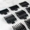 A collection of black hair clipper guards arranged on a light gray surface. Podgląd zdjęcia produktu