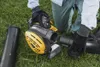 A person wearing gloves is assembling a leaf blower on a grassy lawn. Produktbild-Vorschau