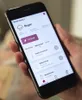 A person is holding a smartphone displaying a smart home app interface. Produktbild-Vorschau