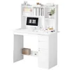 A white computer desk with shelves and drawers, featuring a monitor, keyboard, mouse, clock, and decorative items. Náhľad obrázku produktu