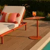 A lounge chair with a pillow and a small side table with a drink next to a pool. Produktbild-Vorschau