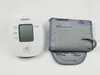 A white Omron blood pressure monitor and a gray blood pressure cuff are laid out on a white background. Náhľad obrázku produktu