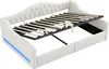 A white upholstered daybed with its mattress support frame raised, showing the storage space underneath. Blue LED lighting is visible along the bottom edge of the daybed frame. Anteprima dell’immagine prodotto