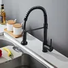 A black kitchen faucet with a coiled hose is shown on a white countertop next to a sink. Produktbild-Vorschau
