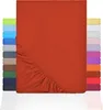 A stack of fitted sheets in various colors, with the main product shown in rust red. Produktbild-Vorschau