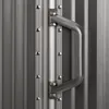 A close-up view of a metal handle attached to a ribbed gray surface, likely a suitcase or door. Podgląd zdjęcia produktu