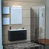 A modern bathroom with a vanity, mirror, and shower. Voir les images du produit