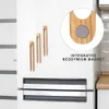 A set of three wooden tongs with integrated magnets attached to a white refrigerator door. Náhled obrázku produktu