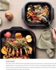 Two roasting pans filled with food, one with roasted vegetables and the other with a rack of lamb and apples, are displayed on a table. Produktbild-Vorschau
