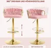 Two views of a pink velvet bar stool with a gold metal frame, illustrating its adjustable height and swivel features. Produktbild-Vorschau