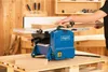 A person is using a blue and gray woodworking machine in a workshop setting. Anteprima dell’immagine prodotto