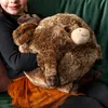 A child is holding a plush reindeer toy. Anteprima dell’immagine prodotto