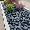 Schwarze Deko-Kiesel als Beetabdeckung mit Pflanzen auf einer Terrasse Produktbild-Vorschau