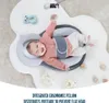 A baby is lying on a soft mat with a pillow designed to prevent flat head. Produktbild-Vorschau