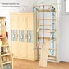 A wooden climbing wall with various accessories is shown next to a wooden wardrobe in a room. Produktbild-Vorschau