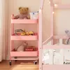 A pink kitchen cart filled with toys and a teddy bear, next to a pink bed frame. Anteprima dell’immagine prodotto