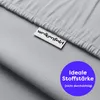 A close-up of light gray fabric, likely bedding, with a brand tag and a circular graphic highlighting a product feature. Produktbild-Vorschau