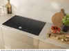 A modern kitchen countertop with an induction hob, cutting boards, and ingredients. Anteprima dell’immagine prodotto