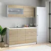 A kitchen cabinet unit with a sink and faucet, next to a refrigerator, with a plant in a pot to the left. Produktbild-Vorschau