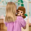 A young girl holding a toy monkey on her shoulder in a room. Podgląd zdjęcia produktu