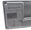 A close-up of a black Kyocera toner cartridge with instructional diagrams and text. Produktbild-Vorschau