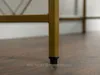 A close-up of the leg of a desk with a gold metal frame and a black foot cap, resting on a wooden floor. Voir les images du produit