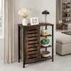 A wooden sideboard with black metal accents is shown in a room setting, next to a window with curtains. The sideboard has shelves with decorative items. Náhled obrázku produktu