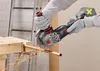A person wearing gloves is using a cordless angle grinder to cut a copper pipe, with sparks flying. Produktbild-Vorschau
