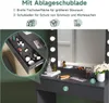 A close-up view of a black vanity table with a drawer open, showcasing makeup and accessories, with a mirror and lights in the background. Voir les images du produit