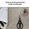 A rug underlay being cut with scissors. Produktbild-Vorschau