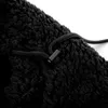 A close-up view of a black fleece material with a drawstring and a plastic toggle. Produktbild-Vorschau