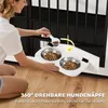 A woman is kneeling on the floor, filling dog bowls with food from a scoop. The dog bowls are attached to a white tray, which is mounted on a black dog crate. Anteprima dell’immagine prodotto