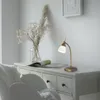 A desk with a lamp, flowers, and a chair. Produktbild-Vorschau