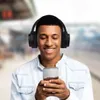 A young man wearing headphones and looking at his phone. Anteprima dell’immagine prodotto