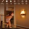A child is looking at a bear-shaped night light mounted on a wall. Produktbild-Vorschau